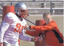  ?? GREG SORBER/JOURNAL ?? Lobos defensive line coach Stan Eggen works with junior college transfer Erin Austin in practice on Wednesday. Austin said he picked UNM because of Eggen’s compelling words to him.