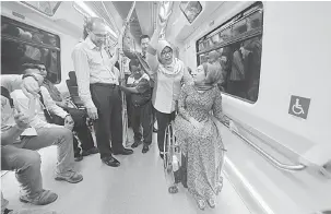  ?? Gambar Bernama ?? TURUN PADANG: Rohani (dua kiri) beramah mesra dengan orang kelainan upaya (OKU) yang merupakan personalit­i terkenal, Ras Adiba Radzi ketika menaiki Transit Aliran Massa (MRT) laluan Sungai Buloh-Kajang (SBK) bersama warga emas dan orang kurang upaya...