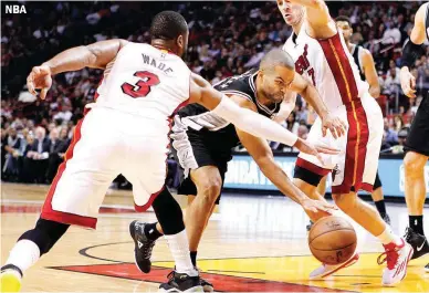  ??  ?? San Antonio Spurs guard Tony Parker drives between Miami Heat defenders Dwyane Wade and Goran Dragic during their NBA game in Miami Tuesday which the Spurs won, 95-81. (AP)