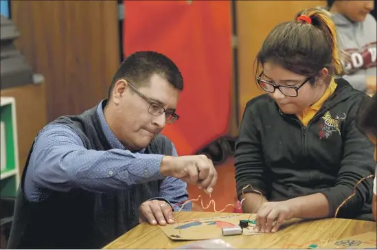  ?? Photograph­s by Francine Orr Los Angeles Times ?? TELFAIR PRINCIPAL Jose Razo helps Angela Carrillo with a project. California ranks 46th in the U.S. in school funding. “We have to do more with less,” Razo says.