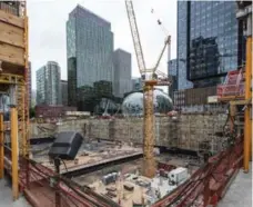  ?? STEVE RINGMAN/SEATTLE TIMES/TRIBUNE NEWS SERVICE ?? The foundation of another Amazon building is being built near Amazon’s Doppler building, left, and its Spheres and Day 1 buildings.