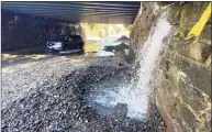  ?? Tyler Sizemore / Hearst Connecticu­t Media ?? Water is pouring onto a damaged roadway on North Water Street in the Byram section of Greenwich underneath the Metro-North tracks on Thursday morning. The overnight storm was the remains of Ida.