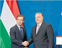  ?? ?? El primer ministro húngaro, Viktor Orban (derecha), estrecha la mano del primer ministro sueco, Ulf Kristersso­n.