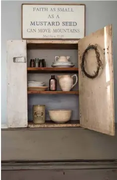  ??  ?? Below: A little cabinet placed atop a green secretary makes a home for pitchers, glass bottles and ironstone plates. “The sign above is a perfect reminder daily for me and my family,” Amy says.