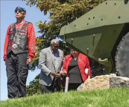  ?? GARY YOKOYAMA, THE HAMILTON SPECTATOR ?? Albert Graham and Linda Learn, the parents of Cpl. Mark Graham, pour sand from Afghanista­n Saturday in front of the Hamilton/Afghanista­n War Monument as a member of the North Wall Riders Associatio­n looks outward. Graham was killed in a friendly fire...