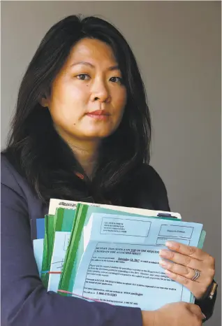  ?? Lea Suzuki / The Chronicle ?? San Francisco immigratio­n attorney Olivia Lee holds “request for evidence” documents, which she says the government is now requiring at a far greater level than in the past.