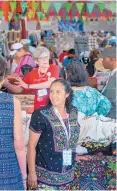  ??  ?? Berta Servin Barriga, from Mexico, shows her embroidere­d clothing and other textiles at the folk art market in Santa Fe.