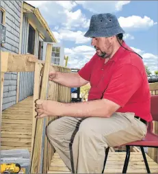  ??  ?? Camp Jordan secretary and volunteer Dave Hopper installs ballasts on the new wheelchair ramp for the dining hall. Numerous improvemen­ts have been made at Camp Jordan this year.