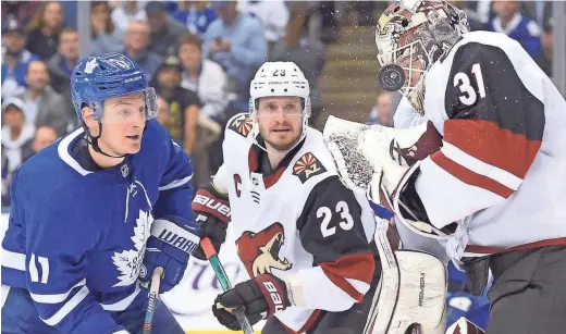  ?? AP ?? Coyotes goaltender Adin Hill (31) makes a save as Maple Leafs left wing Zach Hyman (11) looks for a rebound and Coyotes defenseman Oliver Ekman-Larsson watches on Tuesday night.