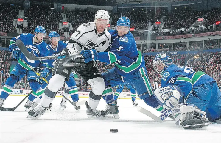  ?? — GETTY IMAGES ?? Vancouver Canucks defenceman Luca Sbisa, second from right, battles with the Los Angeles Kings’ Jeff Carter in front of Ryan Miller Wednesday at Rogers Arena.