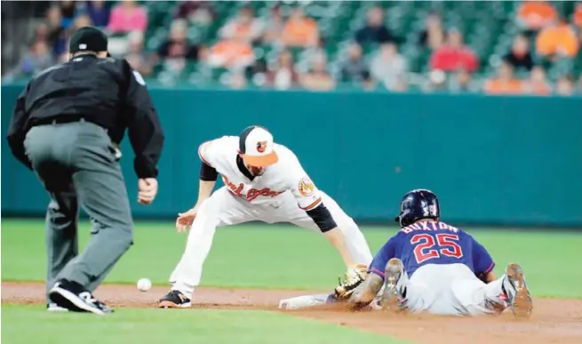  ?? — AFP ?? BALTIMORE: Byron Buxton #25 of the Minnesota Twins steals second base in the sixth inning as the throw gets away from JJ Hardy #2 of the Baltimore Orioles at Oriole Park on May 22, 2017.