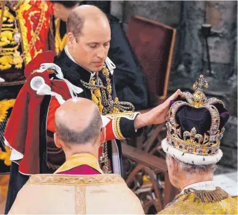  ?? FOTO: YUI MOK/DPA ?? William, Prinz von Wales, berührt die Edwardskro­ne bei der Krönungsze­remonie von König Charles III. Wenn er selbst einst gekrönt wird, will William modernere Akzente setzen.