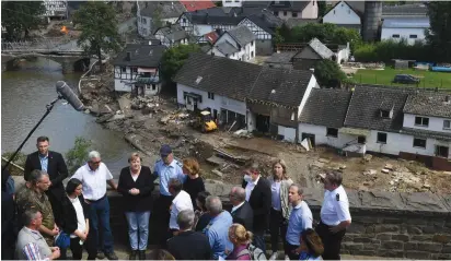  ?? (Christof Stache/Reuters) ?? GERMAN CHANCELLOR Angela Merkel and Rhineland-Palatinate Premier Malu Dreyer speak to people during their visit to the flood-ravaged state yesterday.