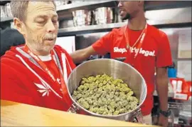  ?? Christina House Los Angeles Times ?? JEFF COSPER shows marijuana for sale at MedMen in West Hollywood last week. The shop handed out free red T-shirts reading, “It’s Legal.”