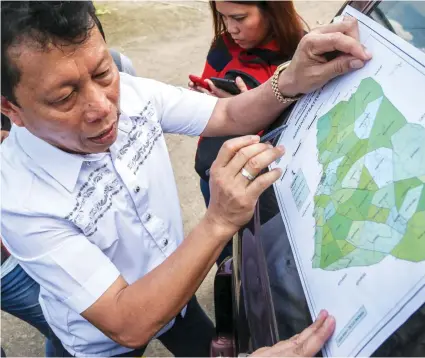  ??  ?? Tuburan Mayor Democrito Diamante Jr. shows a map of the 16 barangays where a combined 2,854 hectares have been devoted to growing coffee trees.