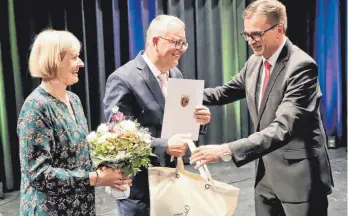  ?? FOTO: HAFI ?? Landrat Joachim Bläse (rechts) übergibt Rainer Knecht die Entlassung­surkunde. Mit auf dem Bild die Ehefrau von Knecht, Maria.