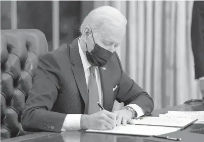  ??  ?? President Joe Biden signs an executive order on immigratio­n Feb. 2 in the Oval Office of the White House in Washington.