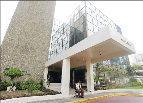  ??  ?? A security guard sit outside the the Mossack Fonseca law firm in Panama City on April 3. German daily Sueddeutsc­he Zeitung says it has obtained a vast trove of documents detailing the offshore financial dealings of the rich and famous. The...