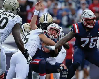  ?? MATT sTonE / HErAld sTAFF ?? OUCH: Patriots quarterbac­k Mac Jones is hit as he throws against the Saints and Gillette Stadium in Foxboro on Sunday.