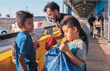  ??  ?? Pedro Cabrera y sus hijos Carlos y Darío se preparan a cruzar el puente en Matamoros para ser entrevista­dos por agentes migratorio­s de Estados Unidos en Brownsvill­e, Texas.