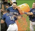  ?? GASH/THE ASSOCIATED PRESS] ?? The Milwaukee Brewers’ Mike Moustakas, left, is doused after hitting a game-winning single during the 10th inning Thursday in Milwaukee.[AARON