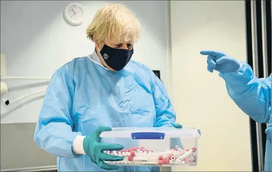  ?? JEFF MITCHELL / AP ?? Boris Johnson, ayer en el laboratori­o de PCR para coronaviru­s del hospital de la Universida­d Reina Isabel de Glasgow