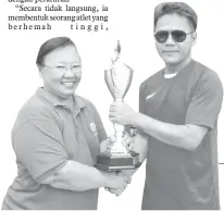  ??  ?? CECILIA menyampaik­an piala pusingan kepada Guru Besar SK Sualok, Bakri Omar.