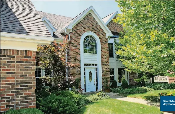  ?? CONTRIBUTE­D PHOTOS BY KATHY TYLER ?? A tall arched front entrance, dormer windows and substantia­l millwork uniting upper and lower bay windows enhance the brick facade of this Vandalia two-story home. Front landscapin­g includes blooming hostas, a Japanese maple tree and several varieties of shrubs and bushes.