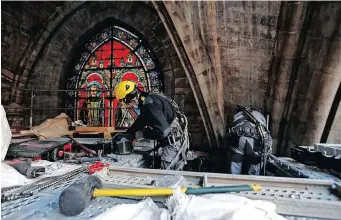  ??  ?? WORKERS at the reconstruc­tion site during a visit of the French President at the Notre-Dame de Paris Cathedral, which was damaged in a devastatin­g fire two years ago, in Paris yesterday. | Reuters