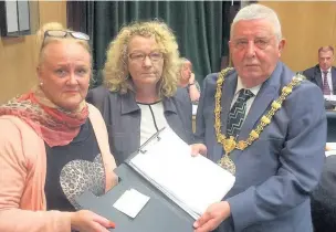  ??  ?? Campaigner­s Kath Gregson and Cheryl Duffy presenting the Peel Street toilets petition to Hyndburn Mayor Peer Britcliffe at a full council meeting