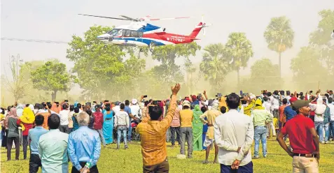  ?? PTI ?? People wave at Uttar Pradesh chief minister Yogi Adityanath’s helicopter as he leaves after addressing a public meeting at Nawada, on Monday, 15 April.
