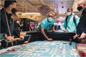  ??  ?? People play craps after the reopening of the Bellagio hotel and casino in Las Vegas on Thursday.