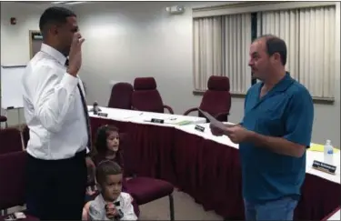  ?? BILL DEBUS — THE NEWS-HERALD ?? Devin DiSantis, left, takes the oath of office from Perry Village Mayor James Gessic to become the newest Village Council member. Standing with DiSantis is his son, Jaxton, while his daughter, Gia, looks on in the background.