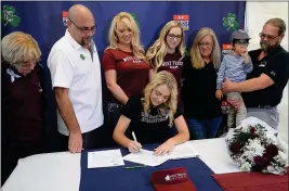  ?? Buy this photo at YumaSun.com PHOTO BY RANDY HOEFT/YUMA SUN ?? YUMA CATHOLIC SENIOR Jordan Grasis (seated) signs a national letter of intent Tuesday to attend and play collegiate golf for West Texas A&amp;M University. Watching Grasis are (from left), her grandmothe­r Pat Grasis; her father and coach Maris Grasis; mother Heather Eynon; sister Kalaina Barnett; grandmothe­r Rosemary Armstrong; nephew Noah Rojas; and grandfathe­r Steve Armstrong.