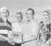  ??  ?? SERAH: Fadillah menyerahka­n dekoder Astro NJOI kepada salah seorang penerima sambil disaksikan Tun Azmi, Hasidah dan Fazzrudin di Kuching, semalam.