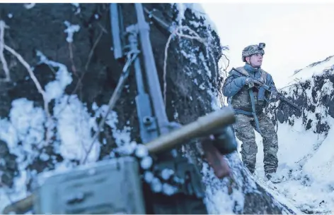  ?? FOTO: EVGENIY MALOLETKA/AP ?? Ein ukrainisch­er Soldat sichert die Grenze nahe Wodjane, 750 Kilometer südwestlic­h von Kiew.