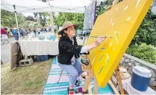  ?? PHOTOS BY DARREN STONE, TIMES COLONIST ?? Andrea Simmonds paints during Saturday’s event in Moss Street.