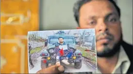  ?? WASEEM ANDRABI /HT ?? Farooq Dar, who was used as a human shield by the Army, holds a picture of him tied to a jeep at Chill village in Budgam district.