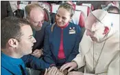  ?? L'OSSERVATOR­E ROMANO VATICAN MEDIA/AP ?? Pope Francis marries Carlos Ciuffardi, left, and Paola Podest, aboard the papal plane. The couple missed a church wedding because of the 2010 earthquake.