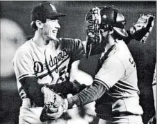  ?? Vince Compagnone Los Angeles Times ?? OREL HERSHISER is congratula­ted by Mike Scioscia after breaking Don Drysdale’s record of pitching 582⁄ straight scoreless innings.
3