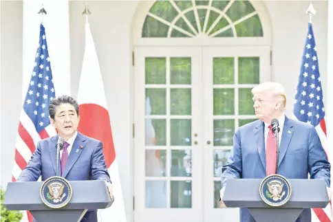  ??  ?? Trump looks on as Abe speaks during a joint press conference in the Rose Garden of the White House. — AFP photo