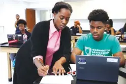  ??  ?? WASHINGTON: Britney Wray, a math teacher at Washington Leadership Academy, helps sophomore Kevin Baker, 15, with a math problem during class in Washington on August 23, 2017. —AP