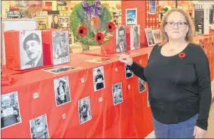  ?? JEREMY FRASER/CAPE BRETON POST ?? Laurie Hatcher, an employee at Atlantic Superstore, stands in front of a Remembranc­e Day display she created at the Northside grocery store. The display features pictures of local veterans as well as pictures of store staff holding a thank you sign,...