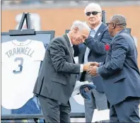  ?? AP PHOTO ?? Detroit Tigers Hall of Fame inductee Alan Trammell, left, shakes hands with former teammate Lou Whitaker after a pre-game ceremony where his number was retired Sunday in Detroit. In the background is Tigers Hall of Famer Al Kaline.