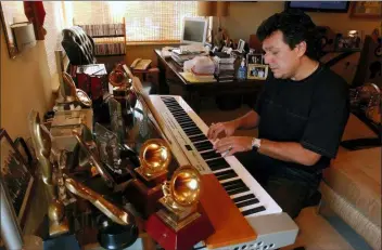  ?? J. PAT CARTER, FILE - THE ASSOCIATED PRESS ?? This 2005 file photo shows Latin songwriter Rudy Perez working on a compositio­n at his home in Miami Beach, Fla. Perez has written a memoir titled “The Latin Hitmaker: My Journey from Cuban Refugee to World-Renowned Record Producer and Songwriter.”