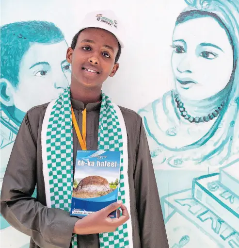  ?? MUSTAFA SAEED / AFP / GETTY IMAGES ?? Abdishakur Mohamed, a 16-year-old author from Somaliland, holds up his book at an internatio­nal book fair in Hargeisa, the capital of Somaliland. At the first event in 2008, organizers exhibited only a handful of books borrowed from friends and attracted just 200 visitors. Ten years on and literature has taken a big place in Somaliland’s culture.