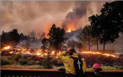  ?? AP PHOTO — NOAH BERGER, FILE ?? In this Aug. 21, 2020, file photo, a firefighte­r rubs his head while watching the LNU Lightning Complex fires spread through the Berryessa Estates neighborho­od of unincorpor­ated Napa County, Calif.