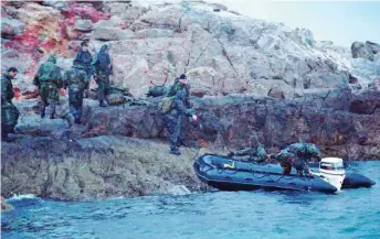  ?? ?? Members of Turkey’s special underwater forces team (SAT) are seen on West Imia, the larger of the two islets, which belong to Greece but whose ownership is disputed by Turkey, on January 31, 1996.