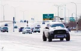  ??  ?? Motorists drive on icy Coors NW near Quail on Sunday. Southbound Coors was closed at Montaño due to multiple wrecks.