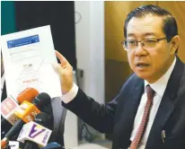  ?? BERNAMAPIX ?? Lim showing reporters the fake circular on GST’s withdrawal purportedl­y on June 1.